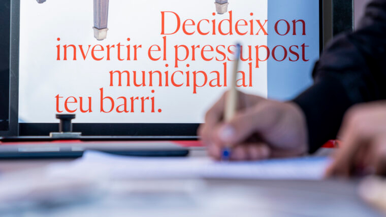 A person signing a document over a sign promoting municipal citizen engagement