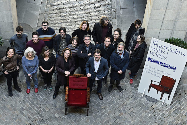 A group of individuals posing for aerial photo in-front of a red chair
